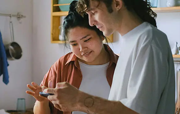 Couple qui met une pièce dans une tirelire en forme de cochon